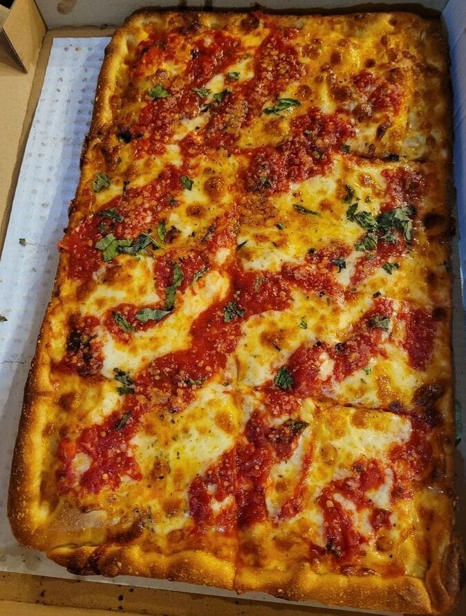 A pizza sitting on top of a pan covered in sauce.